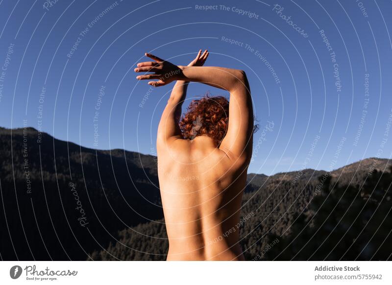 Expressive back of a dancer against mountain backdrop contemporary nature freedom artistic expression clear sky mountainous horizon performance body outdoor