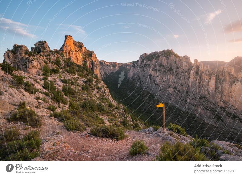 Serene mountain landscape at sunset with hiking trail sign nature serene tranquil evening golden light peaks outdoor adventure path direction marker scenic