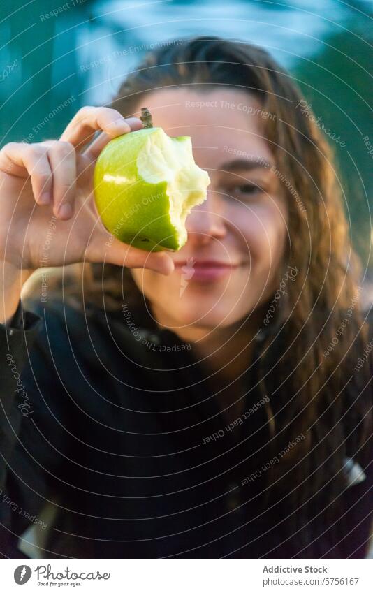 A vibrant snapshot captures a smiling skateboarder holding a bitten apple, taking a refreshing break on a city bridge smile bite woman fruit healthy snack pause