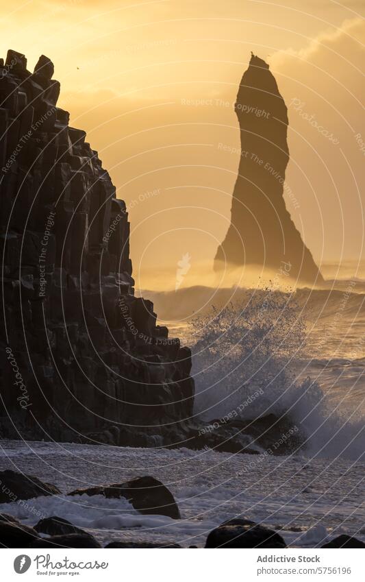 Majestic seascape in Iceland with towering sea stack iceland sunset golden hour waves basalt columns silhouette coastline nature travel tourism tranquil serene