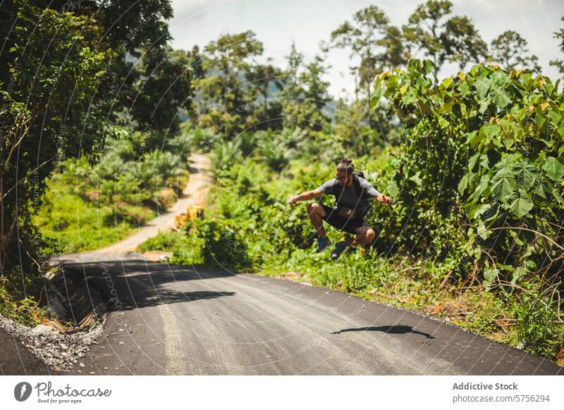 Adventurous jump on a scenic Indonesian road traveler adventure joy rural tropical forest indonesia lush scenery nature backpack exploration outdoor activity
