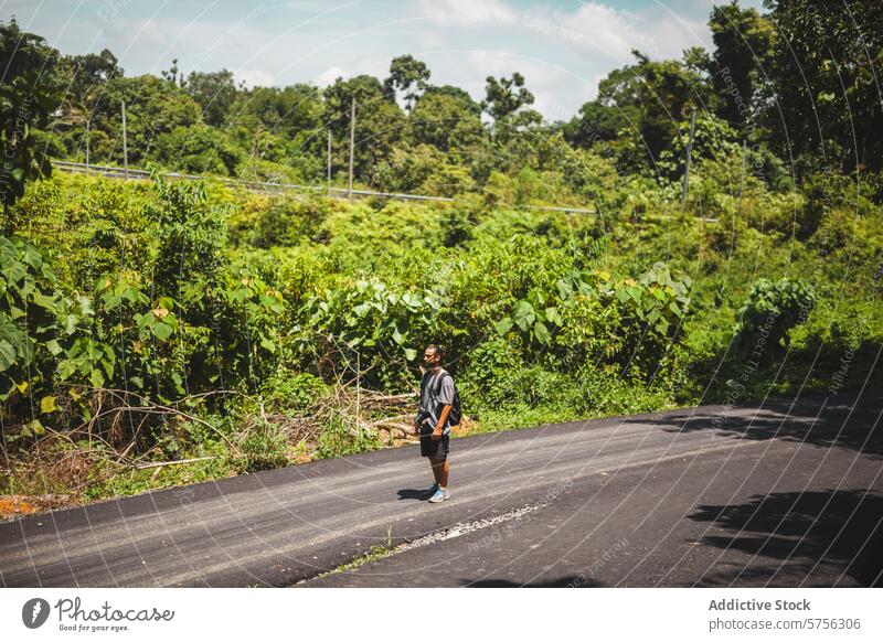 Solo traveler wandering on an Indonesian road indonesia exploration adventure solo journey countryside lush greenery desolate man nature scenic outdoor tropical