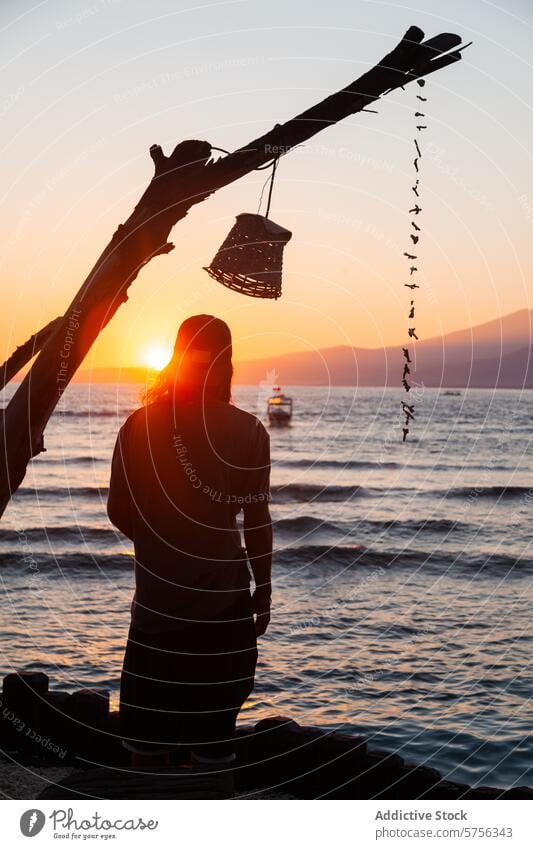 Sunset serenity by the sea in Indonesia indonesia beach sunset silhouette person lantern tranquility ocean travel tourism coast leisure vacation nature scenic