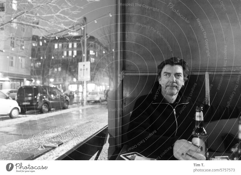Man with bottled beer at the window of a bar Bar Window b/w Black & white photo Night Prenzlauer Berg Berlin Town Downtown Capital city Old town bnw