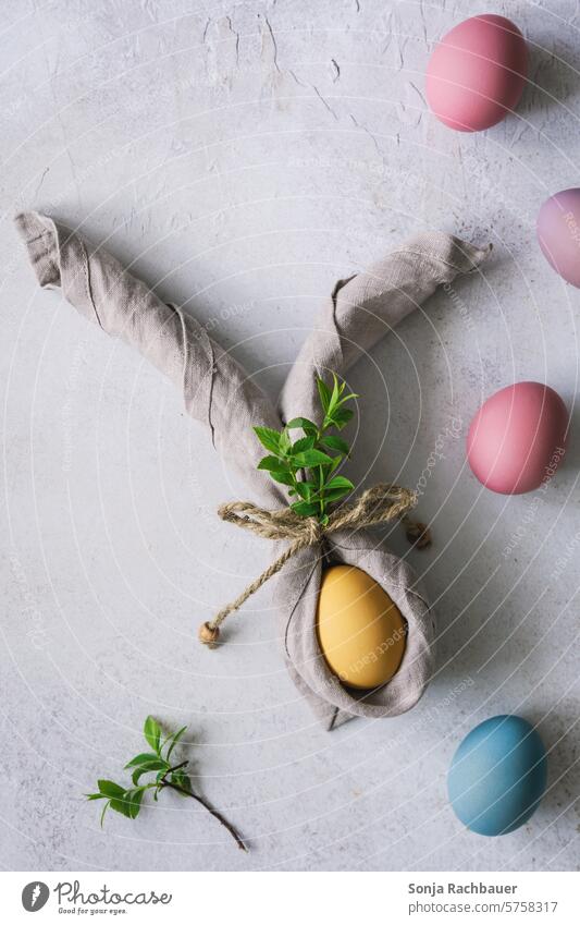 A yellow Easter egg with bunny ears made from a napkin. Top view. Hare ears Napkin Easter Bunny Spring Feasts & Celebrations Tradition Decoration