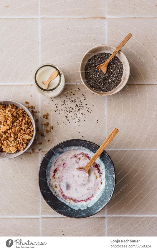 Yogurt with berries in a bowl on a beige tile background. Top view. Breakfast Yoghurt Berries Cereal granola sciatic seed Bowl Spoon Diet Organic Dessert Fruit