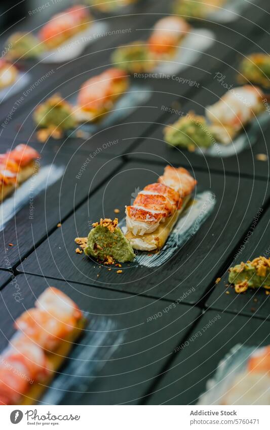 Luxurious lobster canapes paired with a dollop of green sauce, meticulously placed on a chic black slate board for a catered event elegant black board catering