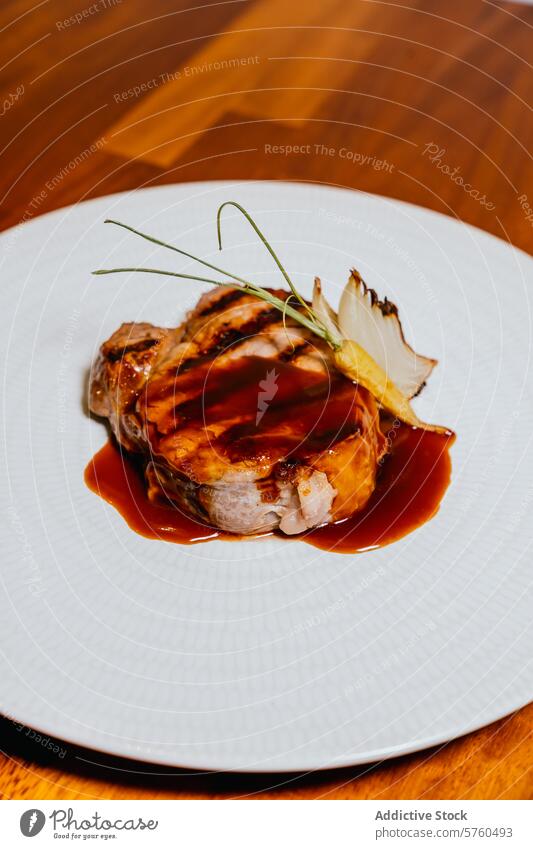 A succulent pork steak drizzled with a rich glaze, garnished with an onion and delicate greens, served on a textured white plate against a wooden background