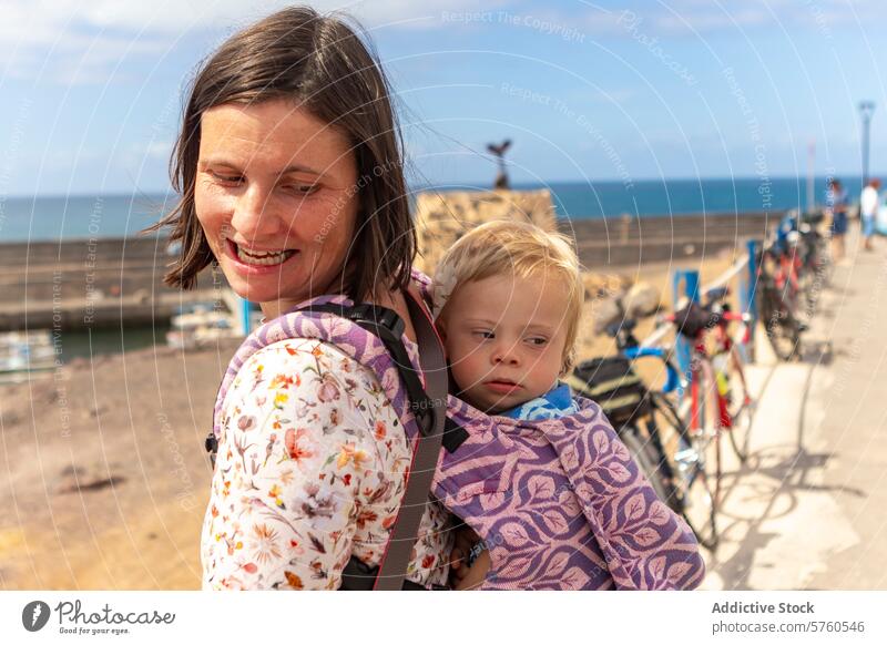 Loving Mother Holding Child with Down Syndrome by the Sea mother child down syndrome affection love family care embrace sea coast gentle smile bond woman