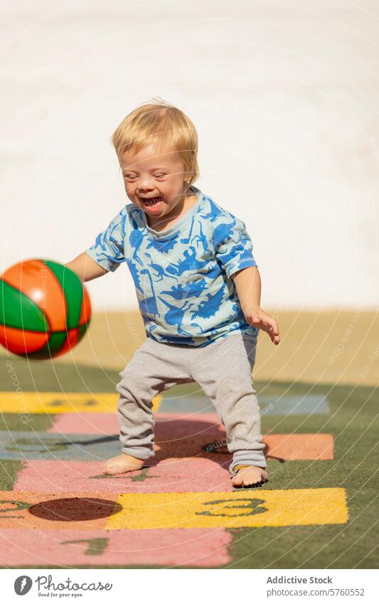 Toddler with Down Syndrome Enjoying Playtime with Ball toddler down syndrome playground ball playtime child happiness innocence sunny outdoor daytime activity