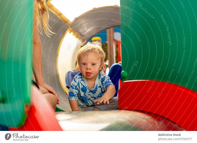 Joyful family moment with a special needs child at a playground down syndrome inclusion diversity playtime tunnel boy joy love togetherness outdoor fun activity