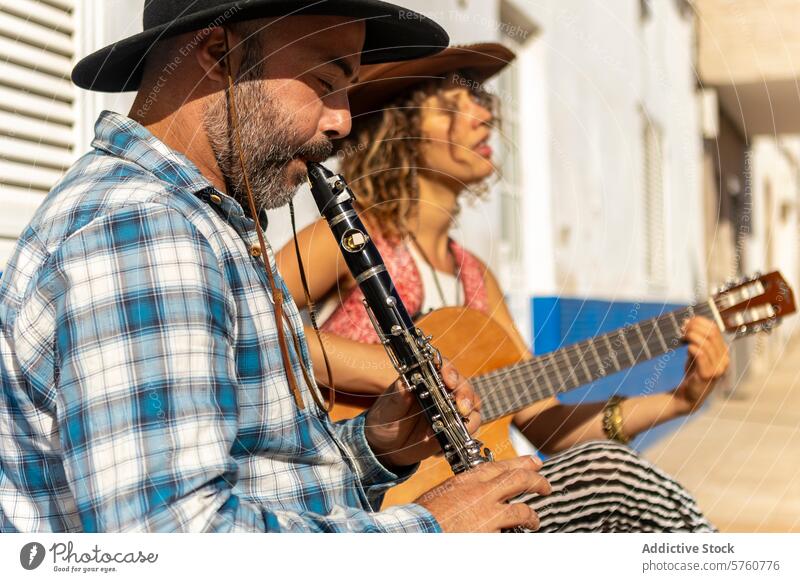 Street musicians playing in a sunny town street duo clarinet guitar day performance talent outdoor artist male female culture acoustic instrument harmony melody
