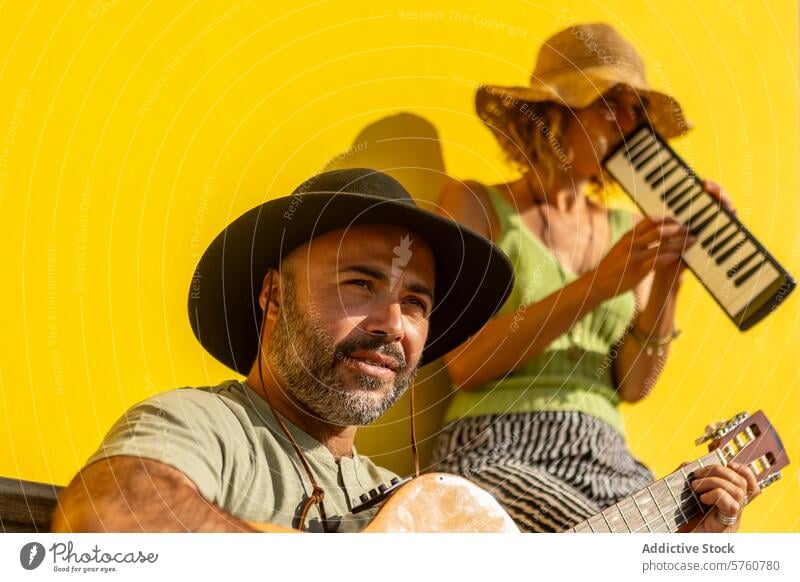 Street musicians performing in vibrant urban setting street duo performer man woman guitar keyboard town performance busker yellow backdrop entertainment