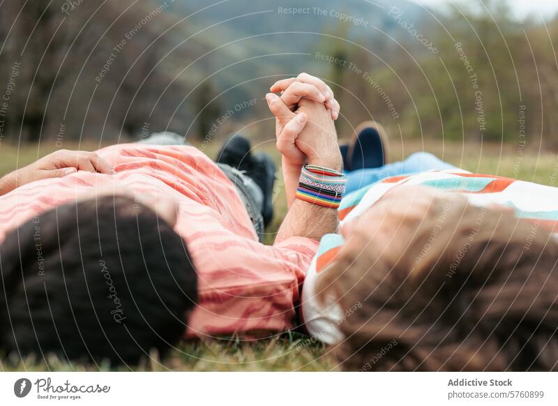 Lying side by side on the grass, a gay couple finds tranquility in nature, their hands clasped in a tender show of love and unity transgender men intimacy