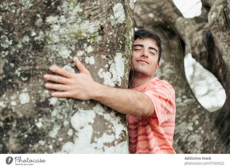 A smiling man joyfully hugs a large, lichen-covered tree, showing a delightful connection with the natural world around him smile nature forest outdoors happy