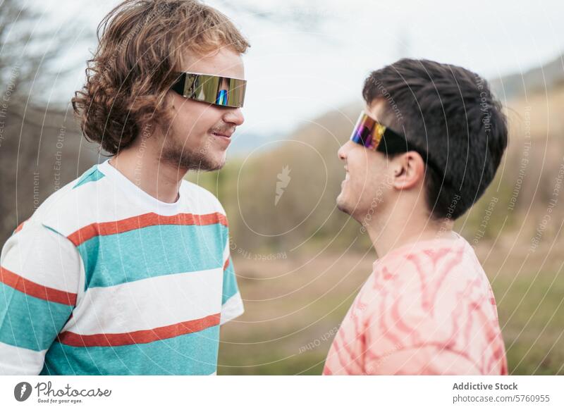 A close moment between two men wearing stylish, reflective sunglasses, suggesting a bond or shared understanding in an outdoor setting fashion friendship happy