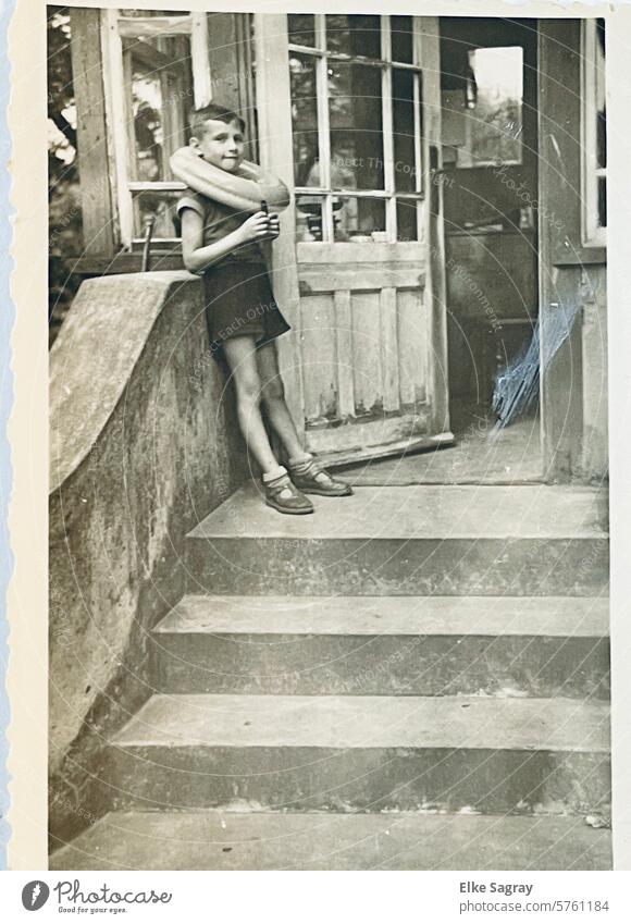 Analog - Boy with swimming tire on a staircase - old children's photo Nostalgia Memory portrait Looking Black & white photo Sentimental Child Photography