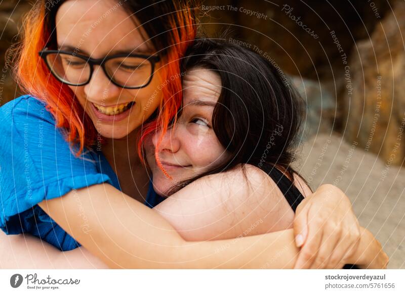 A couple of girls hug each other with affection and joy during a day at the beach person together female friendship fun hugging adult women smile beauty