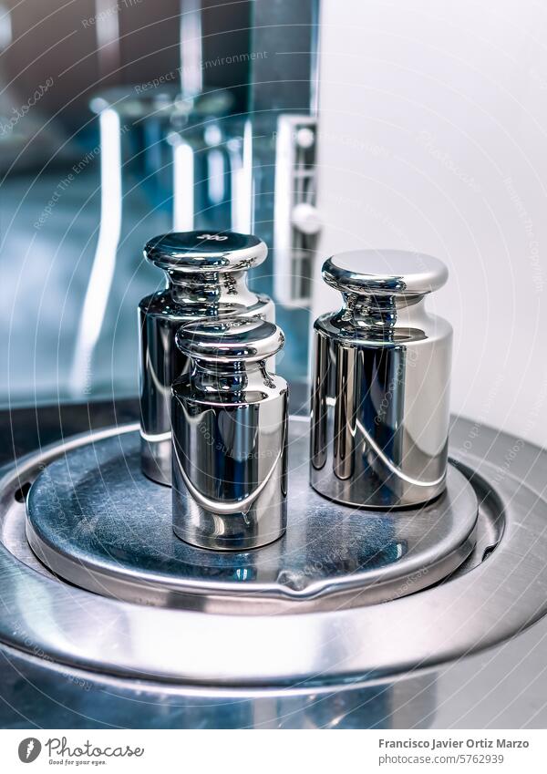 Close-up of the weights used to calibrate an analytical balance. calibration laboratory scale steel pharmacy precision closeup heavy kilogram symbol metal