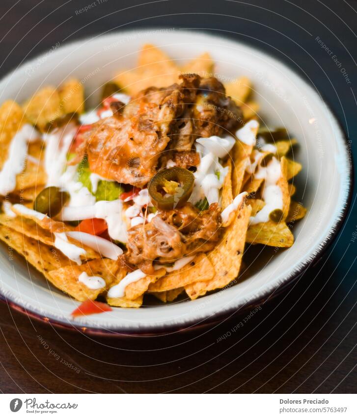 Serving of nachos with meat, cheese, white sauce and jalapenos junk food carbohydrates mexican food latino pulled pork nachos serving nutrition recipe lime