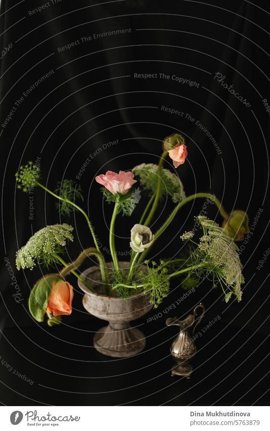 sophisticated intricate flowers bouquet in vase. Floral arrangement on black fabric background. floral bloom blossom bunch nature decoration natural beautiful