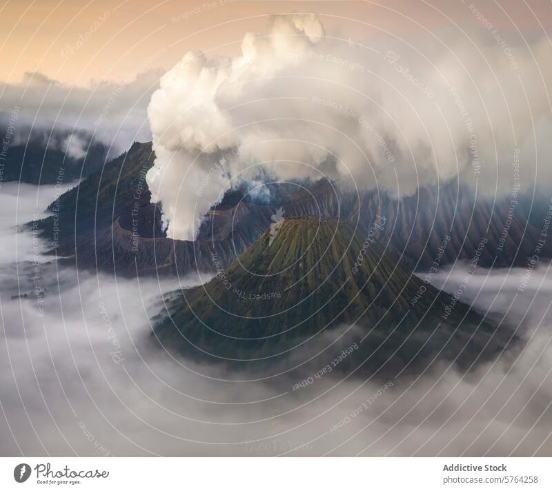 A breathtaking view captures the volcanic eruption's smoke rising above the mist-shrouded mountains at dawn, with soft light caressing the scene volcano clouds