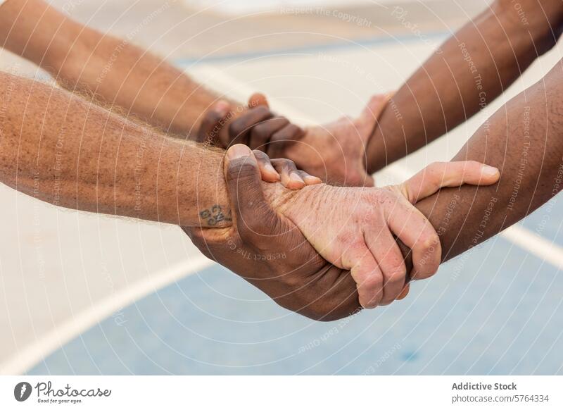 Close-up of multiethnic basketball players' hands gripping each other in a circle, displaying a powerful symbol of team commitment and trust unity strength