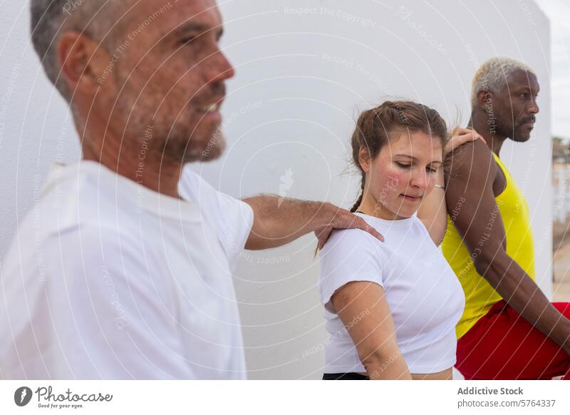 A focused group of people in casual sportswear engage in stretching exercises before starting their outdoor basketball session diversity fitness preparation