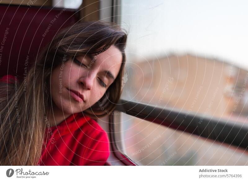 Contemplative woman resting on a train journey head window eyes closed reflective contemplative peaceful young thinking travel transportation relax calm serene