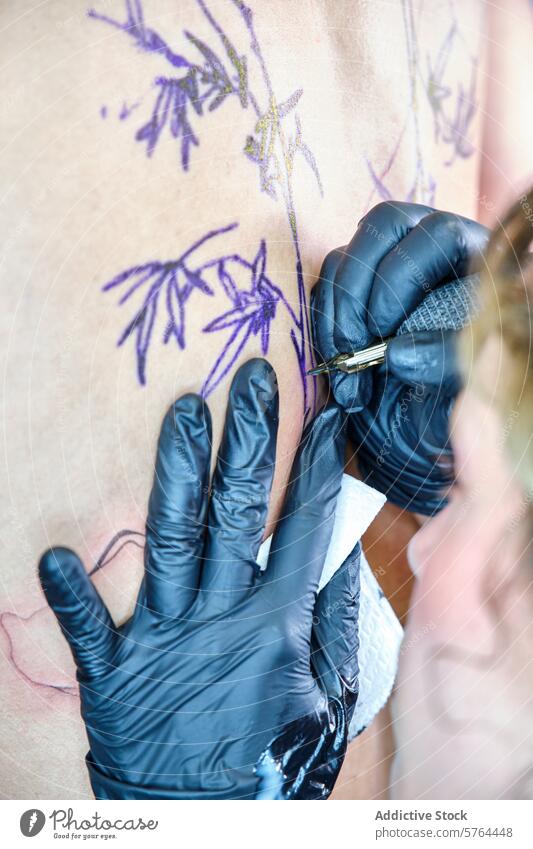cropped unrecognizable tattoo artist at work in a professional studio woman client skin design tattooing close-up tattooer needle ink glove detailed body