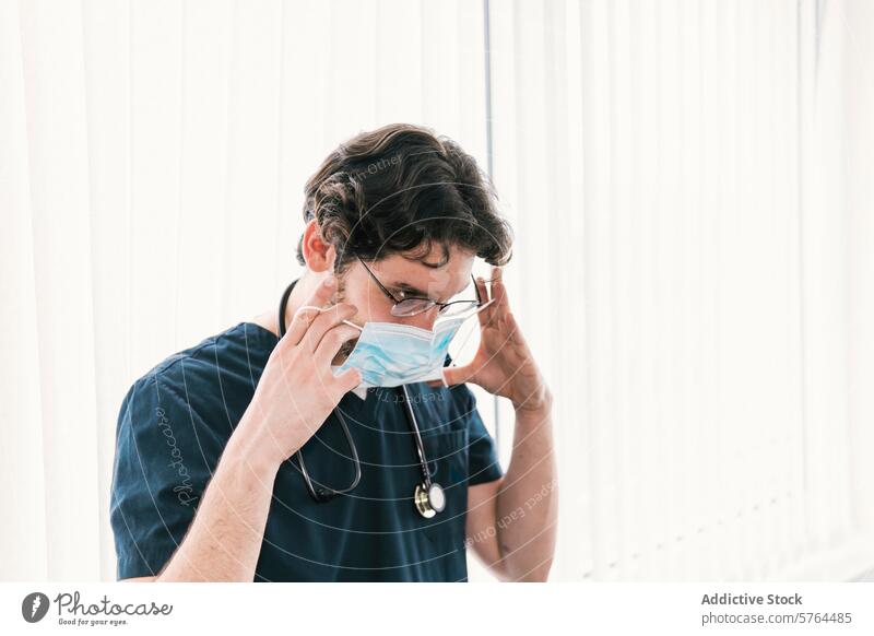 A healthcare professional is captured in the act of adjusting a surgical mask, emphasizing the importance of safety measures worker protective face mask clinic