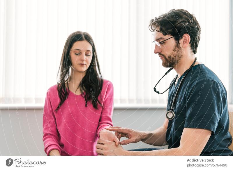 A doctor is attentively examining the elbow joint of a female patient, indicating a careful musculoskeletal evaluation physical healthcare clinic medical scrubs
