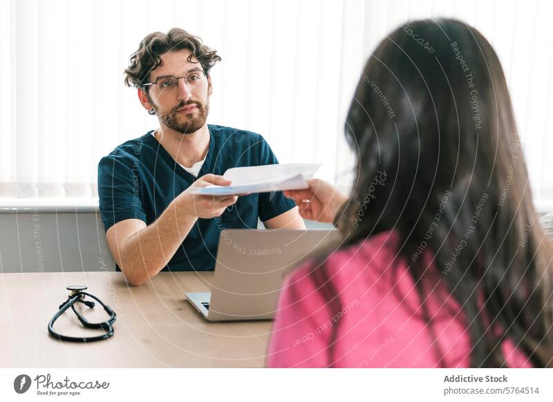 In a clinic setting, a doctor is seen providing important medical paperwork to a patient, highlighting the collaborative care process handing information