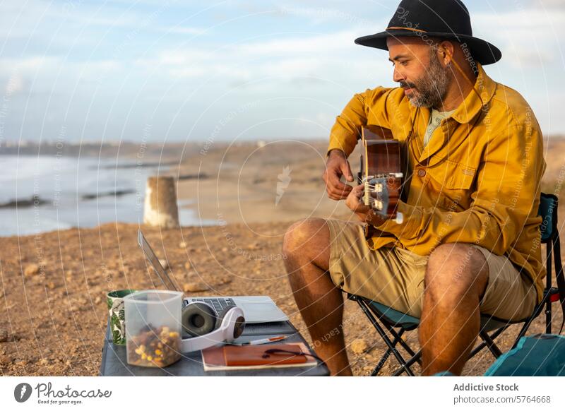 Nomadic man Musician Composing with laptop by the Sea at Sunset musician guitar sea sunset nomadic motorhome inspiration seaside melodies composing lifestyle