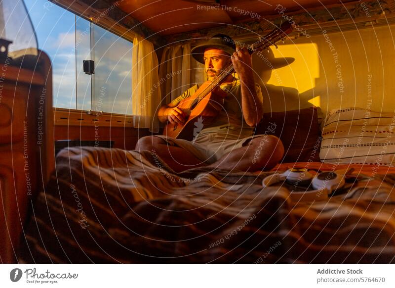 Nomadic Musician Composing by Sunset in Motorhome musician man guitar motorhome sunset sea inspiration nomadic composing cozy light warm interior lifestyle