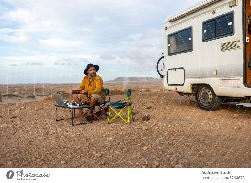 Nomadic Musician Creating Outside His Motorhome musician man nomad motorhome desert composing laptop travel lifestyle serene landscape creativity inspiration