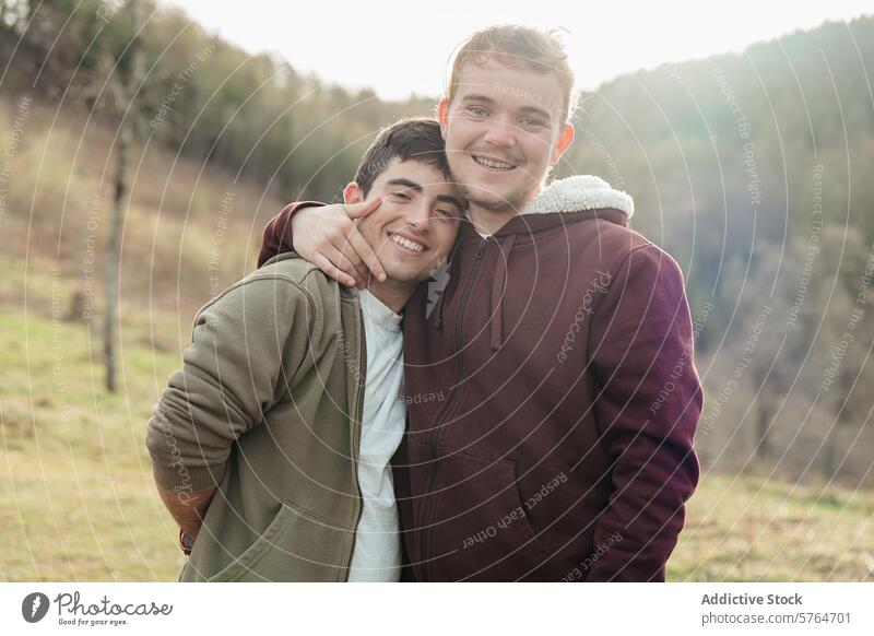 A happy couple enjoys a sunny day outdoors, sharing a smile and a warm embrace in a beautiful natural setting smiling sunshine gay love cheerful relationship