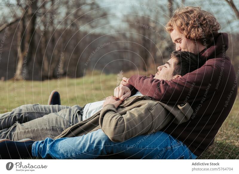 A gay couple relaxes in each other's arms, enjoying a quiet moment of intimacy and comfort on a soft grassy field under the open sky embrace tranquil love