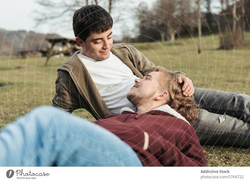 A couple relaxes in a meadow, with one lying in the other's lap, sharing a moment of affection as they gaze into each other's eyes glance love grass outdoor