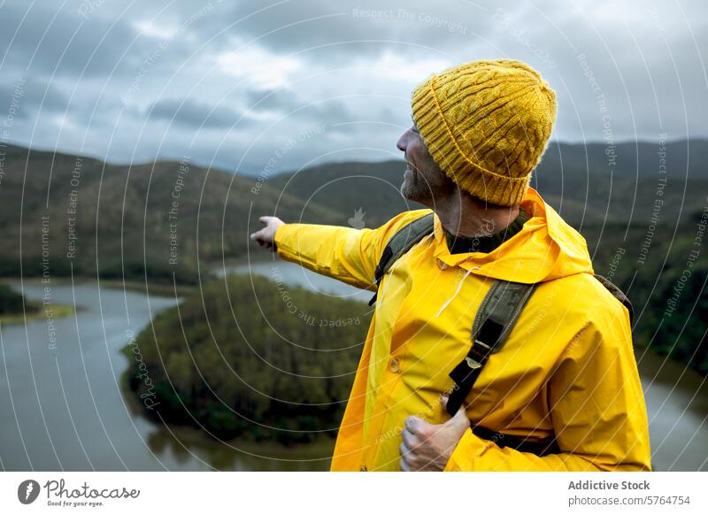 Exploring the Winter Landscape beside a Serpentine River adventurer yellow jacket beanie winter river man valley exploration landscape outdoor travel nature