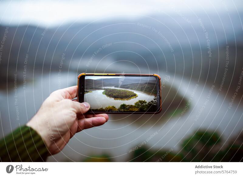 Smartphone Capturing a River Meander in Winter smartphone river meander winter mist hand landscape overcast screen trees photography nature outdoor scenic