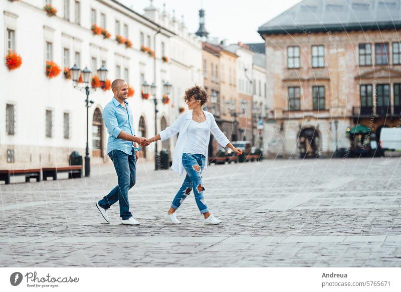 guy and a girl happily walk in the morning on the empty streets young hairstyle brown alone stone walls old fashionable europe joy counting emotions glasses
