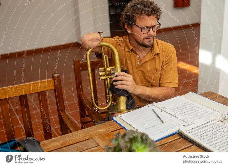 Determined one-armed man practicing trumpet at home trumpeter male practice music instrument sheet note table courtyard bright focus determination perseverance