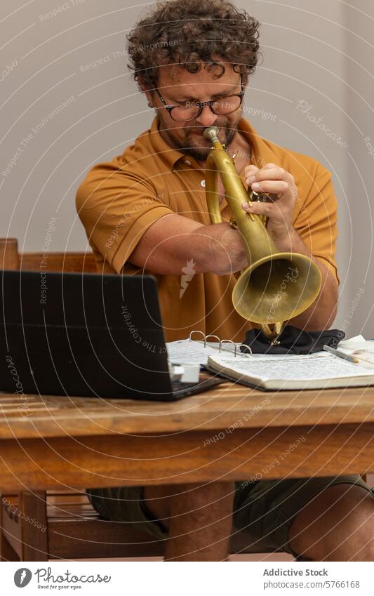 One-armed trumpeter playing and composing music one-armed creative process home courtyard laptop man male musician dedication sheets concentration notes skill
