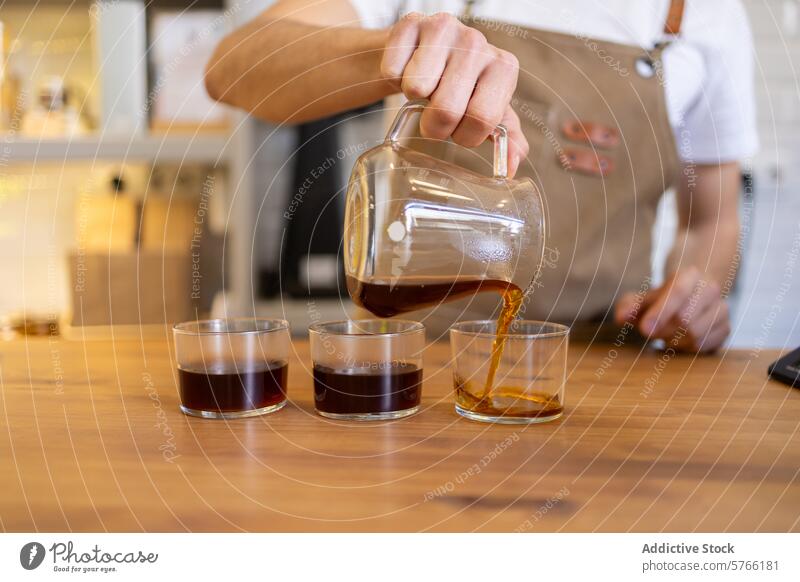 Barista pouring fresh coffee into cups on wooden table barista clear decanter steaming cafe drink beverage glass brewing serving apron hand brown liquid
