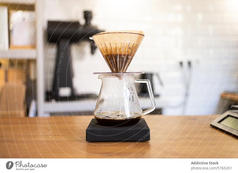 Manual coffee brewing equipment on a scale in a cafÃ© carafe drip filter manual process glass digital ground bean barista pour-over tabletop wooden indoors
