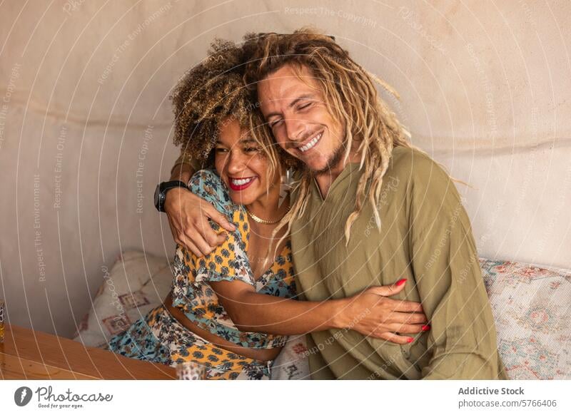 Joyful Embrace of a Cheerful Couple rasta black woman afro multiethnic afro hair couple embrace joyful happy dreadlocks laughing affectionate warm happiness