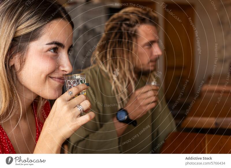 Subtle smiles and shared drinks in a cozy bar atmosphere woman shot glass tasting relaxed coziness friends enjoyment leisure casual socializing gathering indoor
