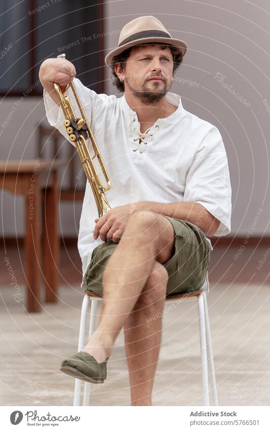 Inspirational one-armed trumpeter practicing outdoors man resilience determination passion music instrument gold chair sitting summer hat white shirt lace-up