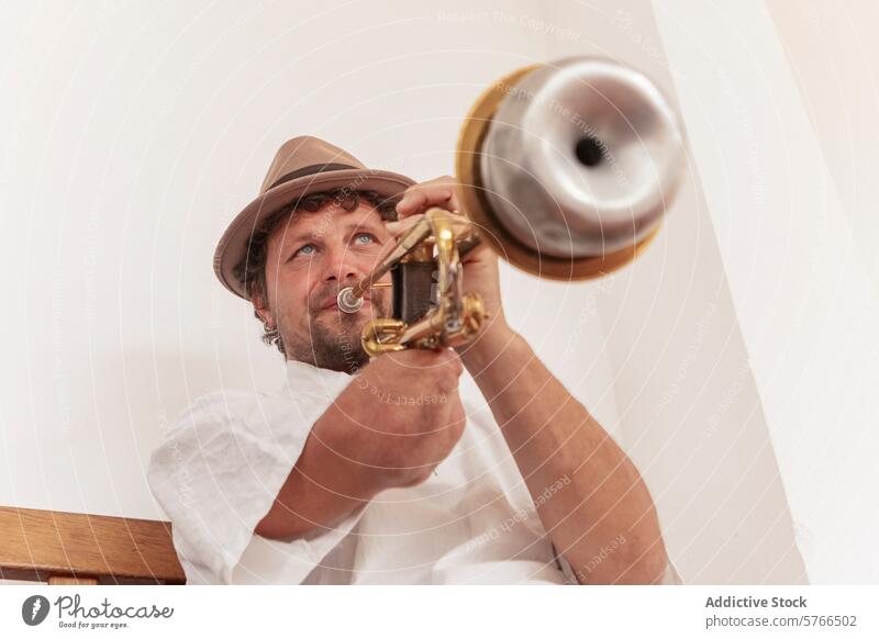Musician With One Arm Practices Trumpet Indoors musician one-armed trumpet practice home hat determination focus craft instrument brass man indoor playing